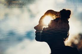 A silhouette of a woman's head superimposed over a calm lake