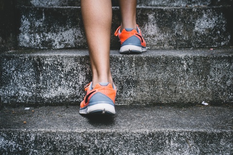 Close up of someone's feet in athletic shoes walking up stairs