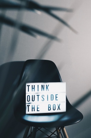 A chair with a sign on it that reads "Think outside the box"